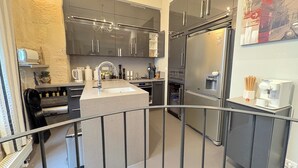 Una cocina moderna con electrodomésticos de acero inoxidable, una isla central y una pequeña zona de café.