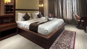 Una habitación de hotel moderna con una cama grande, un escritorio y una silla.