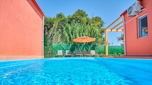 A swimming pool with clear blue water, surrounded by a wooden pergola and a green fence. - Drastis Escape Villas - Villa Ruth by Estia (Corfu)
