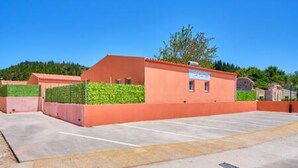 Een parkeerplaats met een gebouw dat een rood dak en een bord met restaurantnaam heeft.