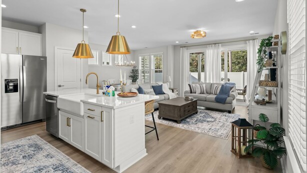 A modern kitchen with white cabinetry, a central island, and pendant lighting. - Luxury New Build in Cherry Grove - Beach and Golf Destination (North Myrtle Beach)