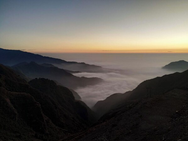 Un paysage montagneux avec une vallée et un ciel dégagé.