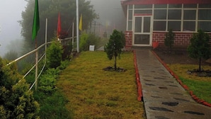 A building with a red roof and a paved pathway leading to its entrance. - Vertical Valley Resort (Kalsi)