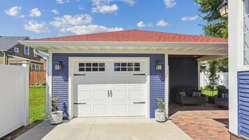 A two-car garage with a covered entryway, a red roof, and a blue exterior wall.