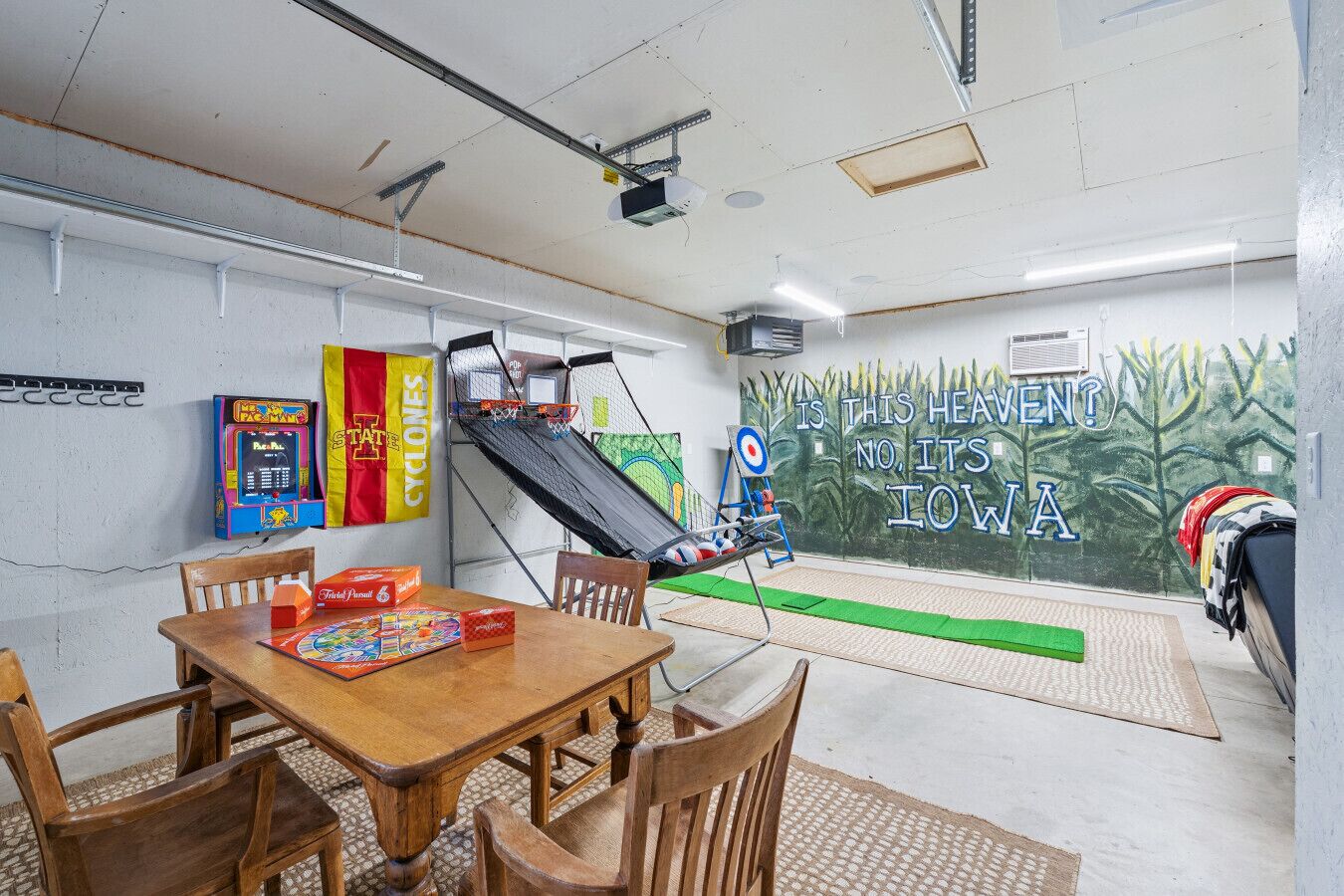 Een kamer met een basketbalring, een dartbord en een muurschildering.