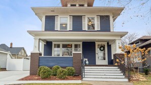 A two-story house with a front porch, a garage, and a small front yard.
