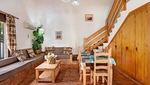 Ein gemütlicher Wohnbereich mit einer Couch, einem Holztisch und einer Treppe.