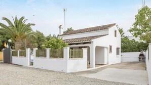 A white house with a tiled roof, a fenced patio, and a chimney. - Holiday Home 'Miguelin 2' with Shared Pool, Wi-Fi and Air Conditioning (Zahora)