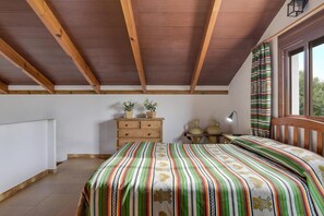 A bedroom with a wooden ceiling, a bed with a striped bedspread, a dresser, a nightstand, and a window with curtains. - Holiday Home 'Miguelin 2' with Shared Pool, Wi-Fi and Air Conditioning (Zahora)
