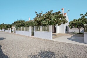 A building with a white facade, a gated entrance, and a clear sky. - Holiday Home 'Miguelin 4' with Shared Pool, Wi-Fi and Air Conditioning (Zahora)