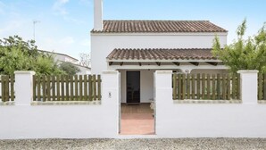 A white building with a tiled roof, a chimney, and a gated entrance. - Holiday Home 'Miguelin 5' with Shared Pool, Wi-Fi and Air Conditioning (Zahora)