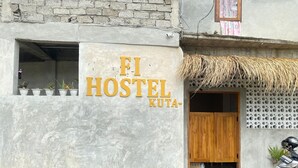 A hostel with a sign reading "FI HOSTEL KUTA" and a thatched roof entrance. - Fi Hostel Kuta (Kuta)