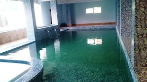 A swimming pool with a tiled floor and walls, surrounded by a tiled border. - Hotel Crown of Digha (Digha)