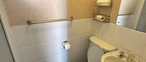 Un baño pequeño con inodoro, lavamanos y espejo.