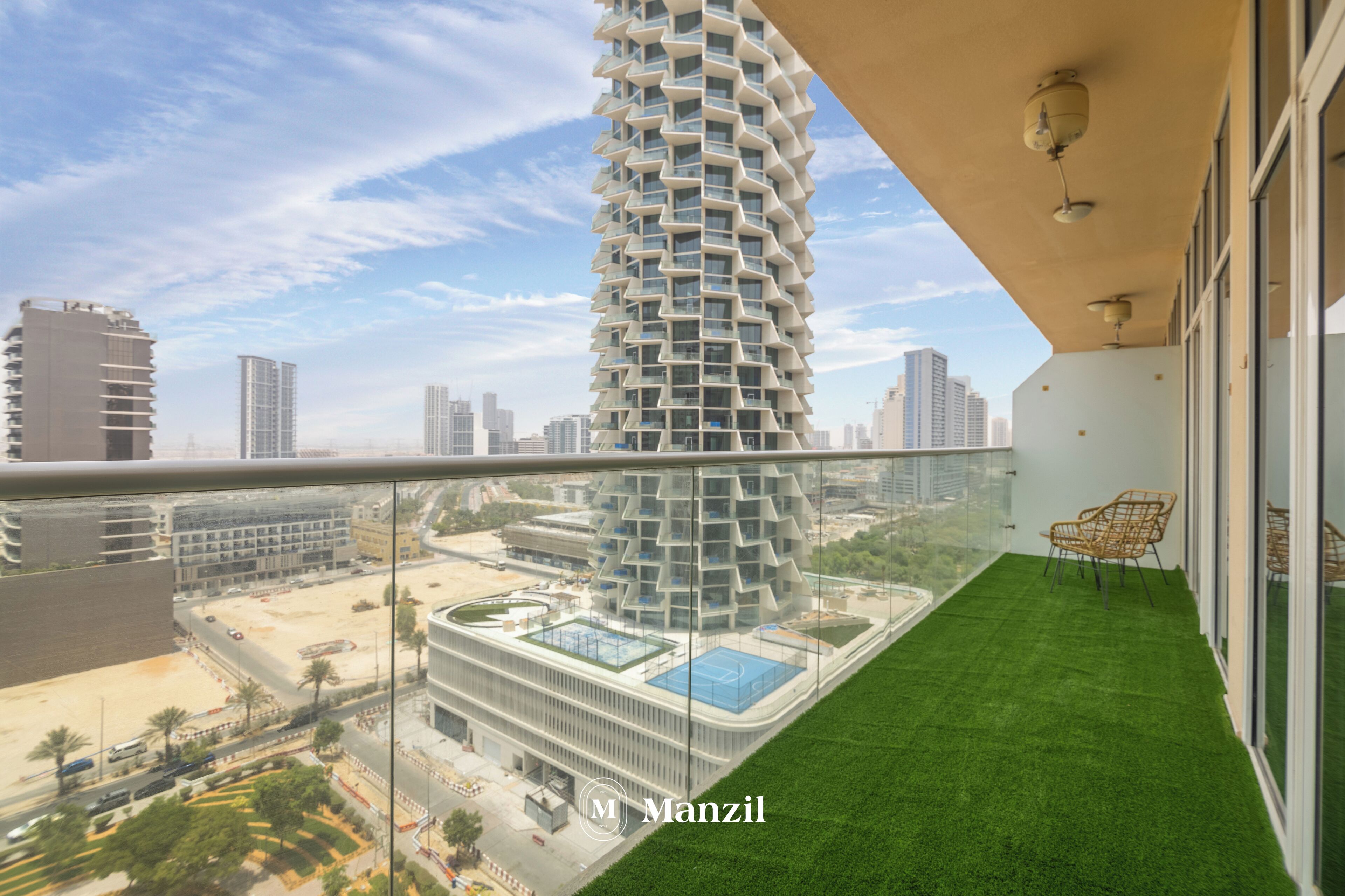 A modern high-rise building with a unique spiral design, a rooftop pool, and a balcony with artificial grass and wicker furniture.
