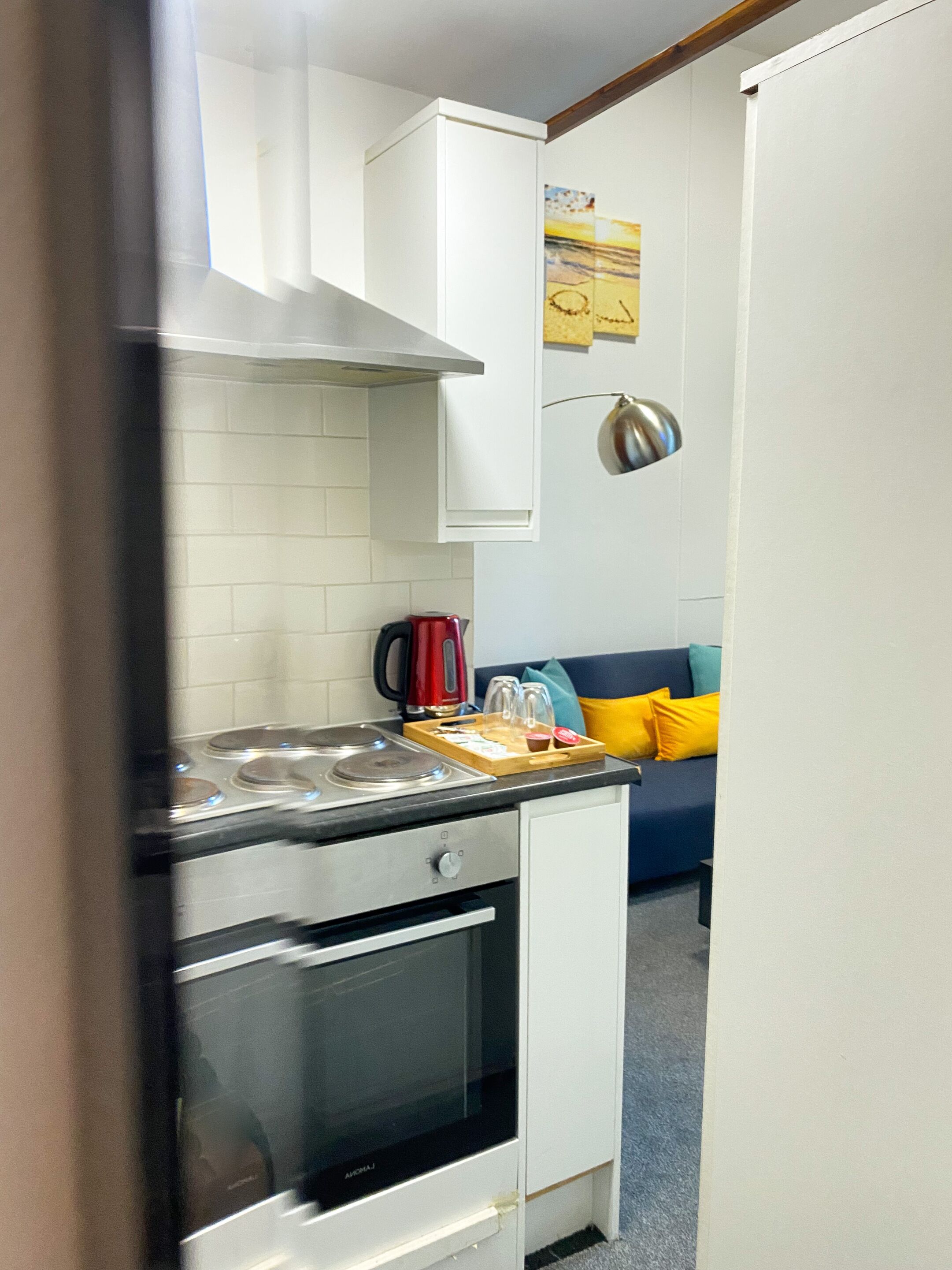 Standaard studio | Privékeuken | Een koelkast, een magnetron, een kookplaat, kookgerei, borden en bestek
