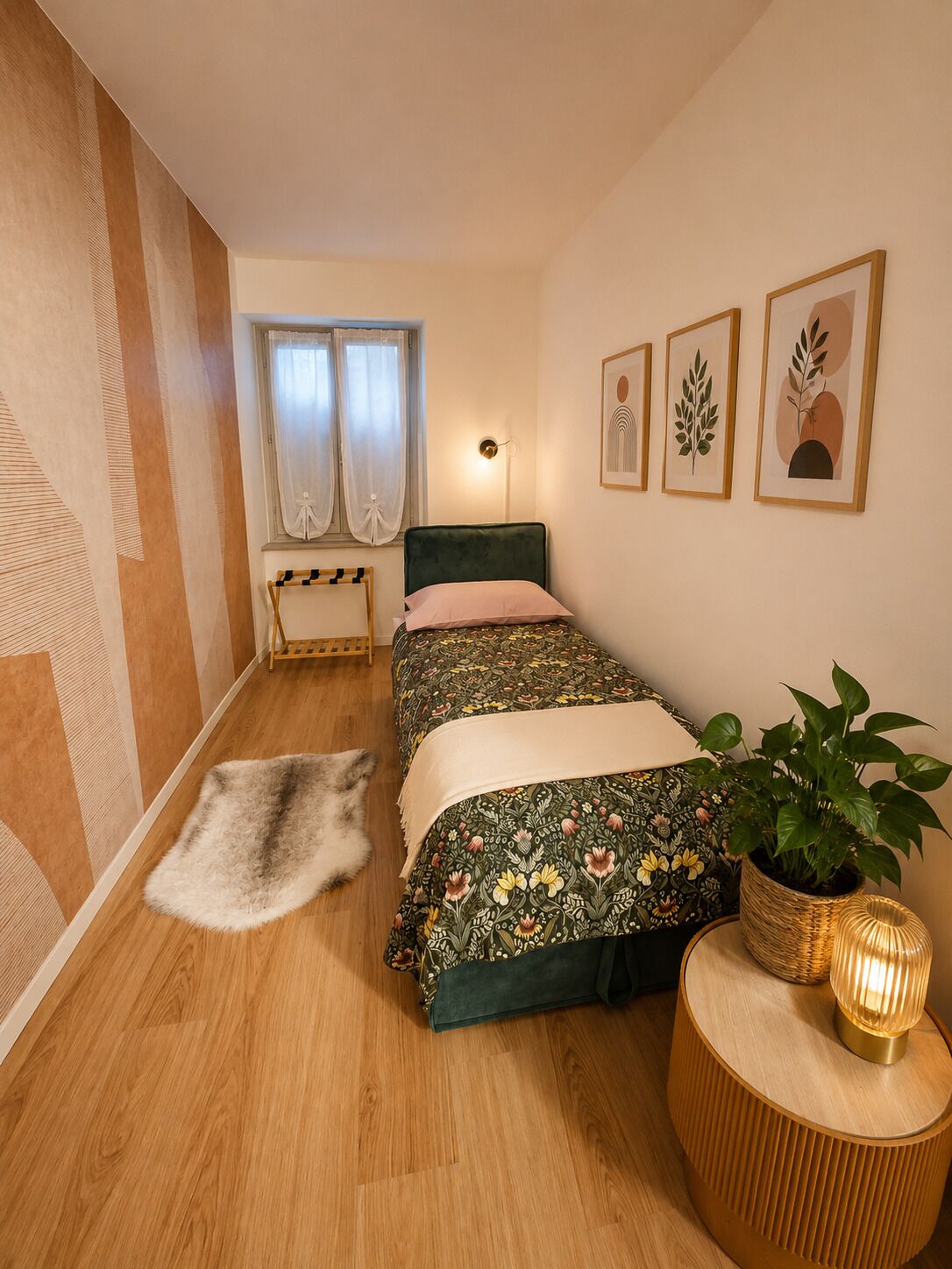 Una camera da letto con un letto, un comodino con una lampada, una pianta in vaso e una finestra con tende.