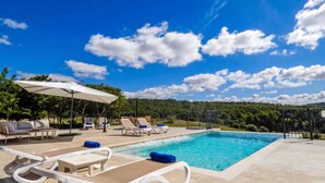 A poolside area with lounge chairs, a table, and an umbrella. - Holiday Home 'Son Pons' with Mountain Views, Wi-Fi & Air Conditioning (Llucmajor)