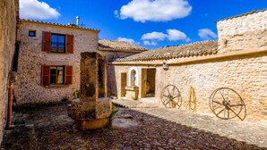 A stone building with a courtyard, a well, and a wheel. - Holiday Home 'Son Pons' with Mountain Views, Wi-Fi & Air Conditioning (Llucmajor)