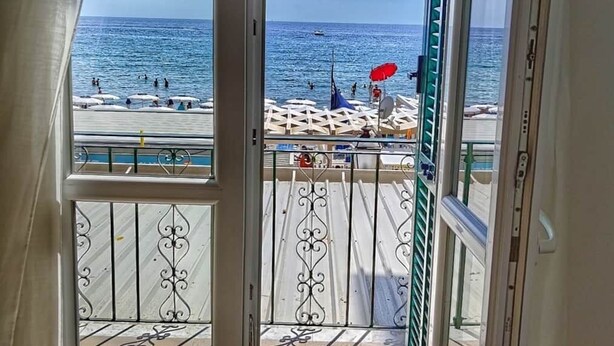 Ein Balkon mit Blick auf das Meer und den Strand.