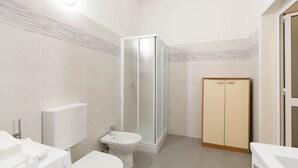 A bathroom with a toilet, bidet, shower, and a cabinet. - Three-room seafront apartment with balcony (Alassio)