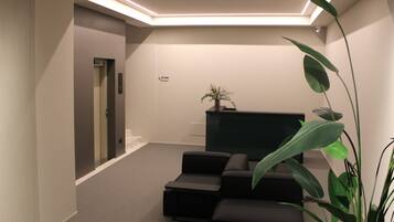 A modern interior with a seating area, a flat-screen TV, and a staircase.