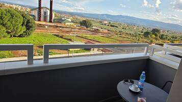 Un balcon donnant sur une église, une table avec une bouteille d’eau et une tasse.