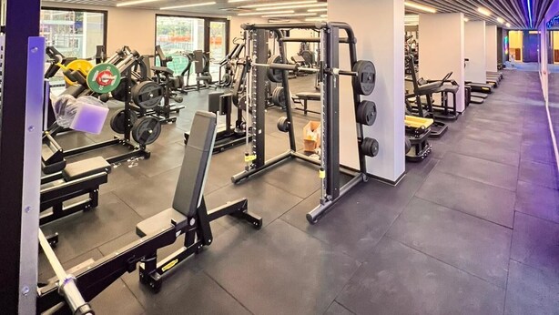Une salle de sport moderne équipée de divers appareils de musculation et de machines de cardio.