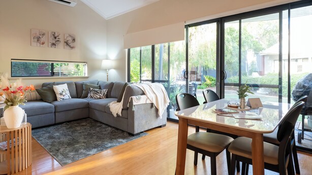 A modern living room with a grey sectional sofa, a wooden coffee table, and a dining area with a glass-top table and chairs. - "Serenity & Sea", Pool, Wi-Fi, Internet, Netfilix/Stan, 500m to Beach, Parking (Preston Beach)