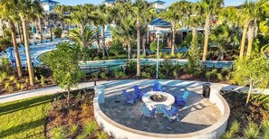A resort with a circular outdoor seating area, palm trees, and a pool. - Luxury 5BR Home | Private Pool Retreat (Davenport)