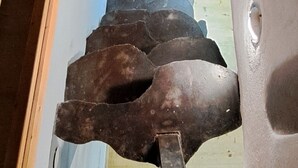 Una escalera de caracol con barandilla de metal y una plataforma de madera en la base.