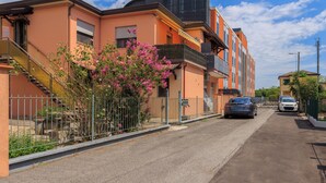 A residential street with houses, a car, and a pink flowering bush. - Marco Polo Airport GATE 2 Comfy 1+1BR Apt with Venice Access (Venezia)