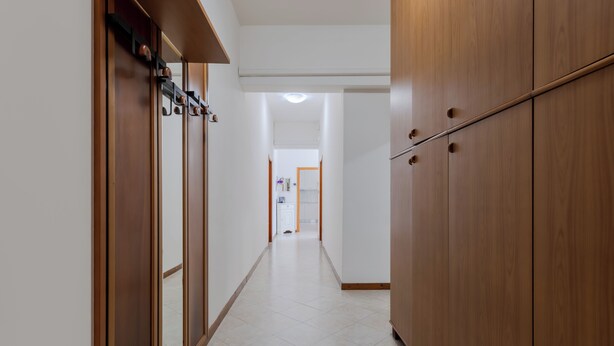 A hallway with wooden cabinets and a tiled floor. - Marco Polo Airport GATE 2 Comfy 1+1BR Apt with Venice Access (Venezia)