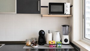 A kitchen with a microwave, coffee maker, blender, and jars of food on the counter. - Room-charming Lisbon Apartment in Quiet (Lisbon)