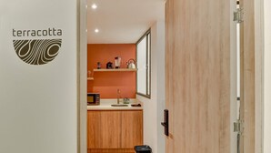 A modern kitchen with wooden cabinets, a microwave, and a sink. - w Beautiful 1BR Retreat in Vibrant Zona T (Bogotá)