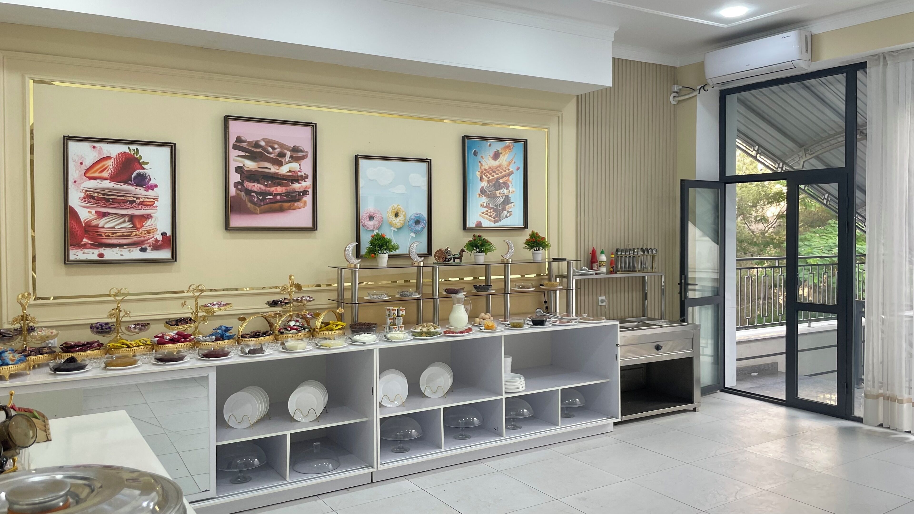 A buffet setup with various food items and a decorative wall with framed pictures.