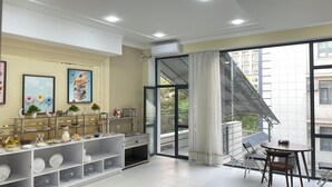 A modern apartment with a dining area, a glass door leading to a balcony, and a view of the cityscape. - Chinor Hotel Fergana (Fergana)