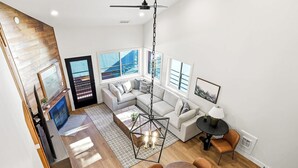 A modern living room with a sofa, coffee table, and dining area. - Giant Steps 30 Ski in/Ski out (Brian Head)