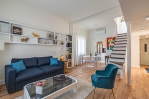 Ein modernes Wohnzimmer mit einer Couch, einem Couchtisch und einem Essbereich mit Stühlen und einem Tisch.
