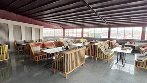 A spacious indoor area with high ceilings and large windows, featuring multiple seating arrangements and a tiled floor. - ELEGRAND HOTEL (Van)