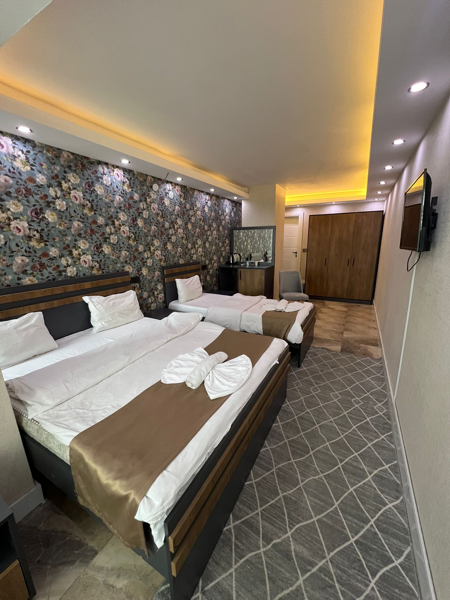 Standard trippelrum - utsikt mot staden | Värdeförvaringsskåp på rummet, skrivbord och arbetsyta för laptop