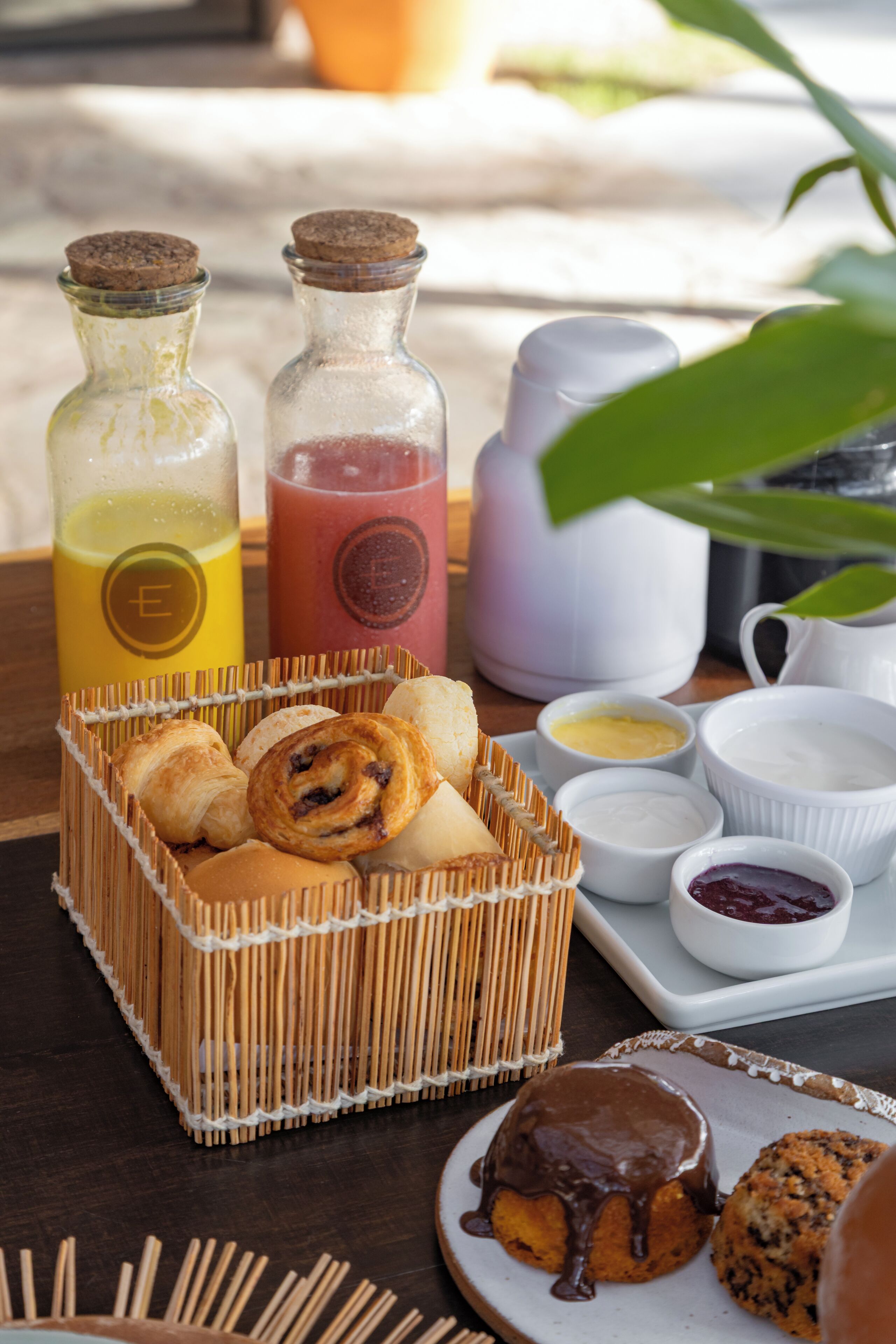 Un desayuno con pasteles, bebidas y salsas sobre una mesa.