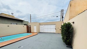 Zona residencial com piscina, garagem e pequeno jardim.