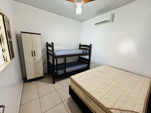 A bedroom with a bunk bed, a single bed, a wardrobe, and an air conditioning unit. - Heated pool, air conditioning, Wi-Fi, near the park. (Olimpia)