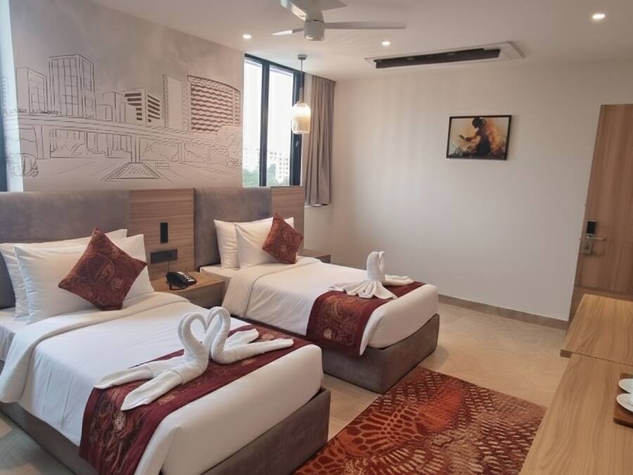 A hotel room with two beds, a large window, a mural, a painting, a TV, and a coffee station.