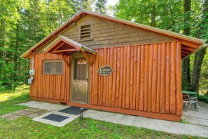 A small wooden cabin with a door, a window, and a sign on the side. - Cozy 'rivershire Retreat Cabin' Near Traverse City (Traverse City)