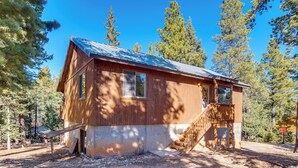 A wooden cabin with a metal roof, a wooden staircase, and a window. - High Noon Hideaway: Zion Cabin w/ Fire Pit! (Duck Creek Village)