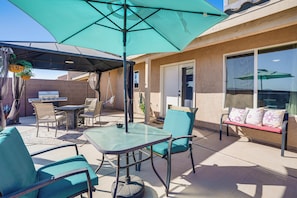 An outdoor patio with a table and chairs, a grill, and a bench with cushions. - Hike, Golf & Explore Yuma: Home w/ Private Patio (Yuma)