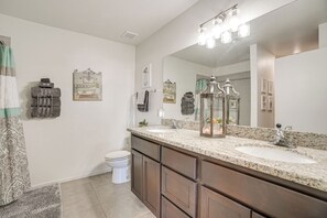 A bathroom with two sinks, a large mirror, and a toilet. There are towels hanging on the wall and a rug on the floor. - Hike, Golf & Explore Yuma: Home w/ Private Patio (Yuma)