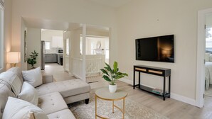 A living room with a sofa, a coffee table, a TV, and a console table.